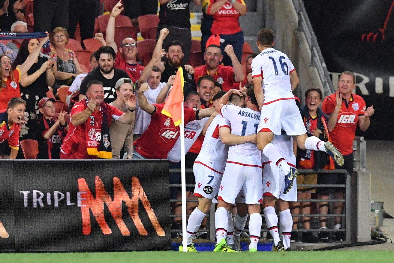 Adelaide United players and supporters celebrate Ryan Kitto's goal against Brisbane Roar. Photo: Darren England / AAP