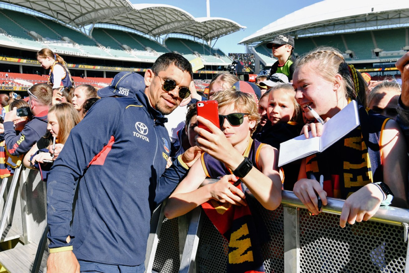 Charlie Cameron of the Adelaide Crows is seen taking a selfie with the crowd after arriving at Adelaide Oval earlier this month to a welcoming home from fans after the AFL Grand Final. Photo: AAP/Morgan Sette
