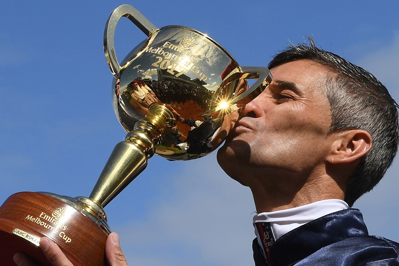 Corey Brown kisses the Melbourne Cup after Rekindling won the Melbourne Cup at Flemington Racecourse today. Photo: Julian Smith / AAP