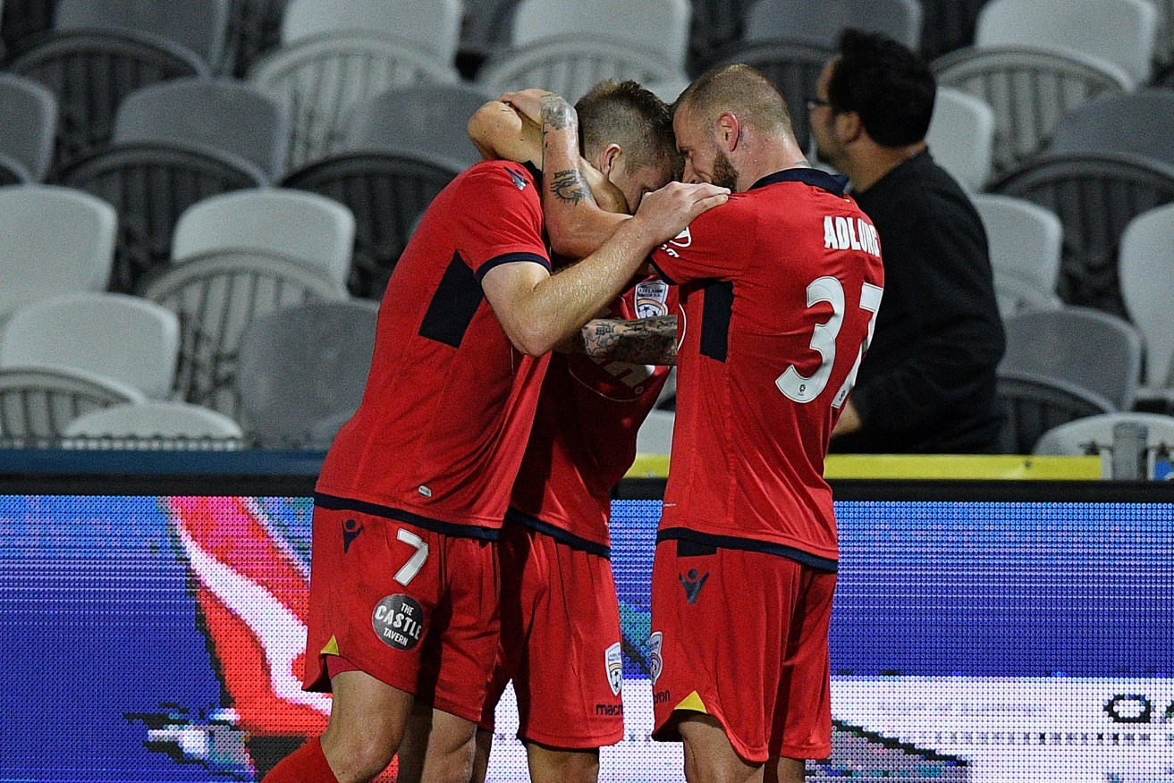 Ryan Kitto celebrates with teammates after scoring the winner last night. Photo: Dan Himbrechts / AAP