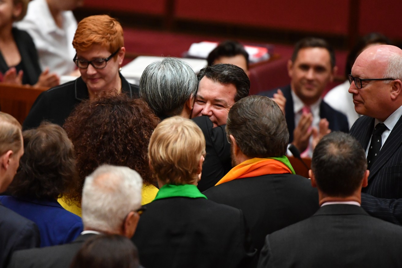 Labor's Penny Wong hugs Liberal Senator Dean Smith after the vote for the same-sex marriage bill in the Senate chamber. Photo: AAP/Mick Tsikas