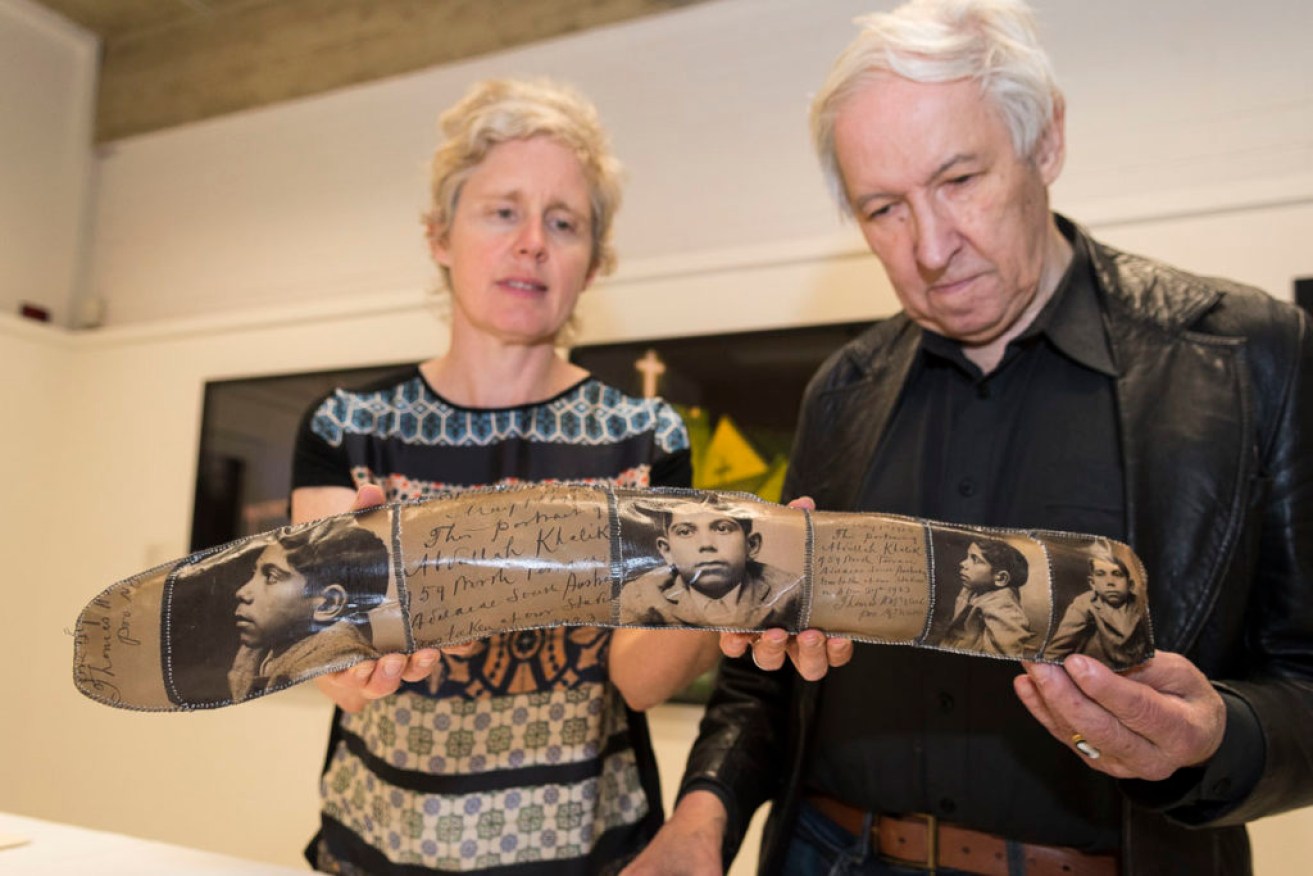 Emeritus Professor Vincent Megaw and Fiona Salmon, director of the Flinders University Art Museum with the donated boomerang designed by Peter Drew and entitled ‘Abdullah and Wizaree’ (2017)