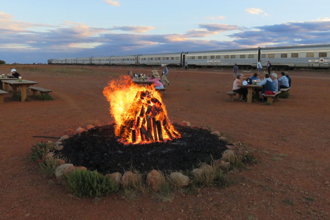 Ghan guests enjoy a campfire at Manguri Siding, near Coober Pedy. Photo: Gregg Tripp/AAP