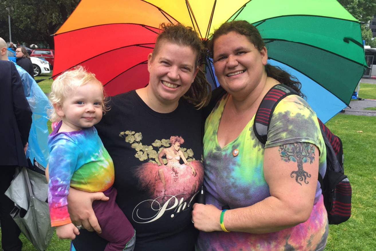 Rose*, her partner Sarah and their daughter Poppy at this morning's marriage equality official results event in Hindmarsh Square. Photo: Bension Siebert / InDaily