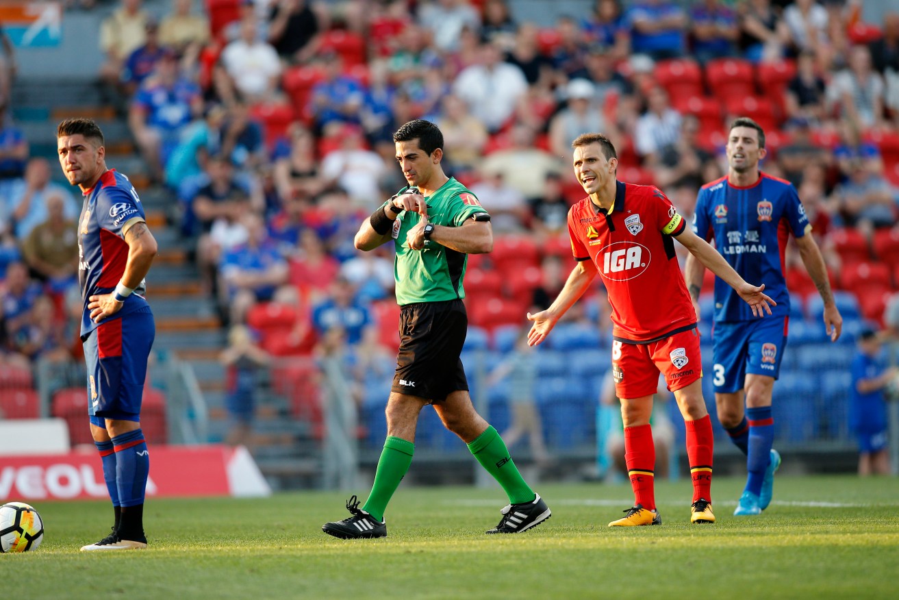 Isaias gets a yellow card for arguing with referee Stephen Lucas over the controversial handball penalty that decided Saturday's game. Photo: Darren Pateman / AAP