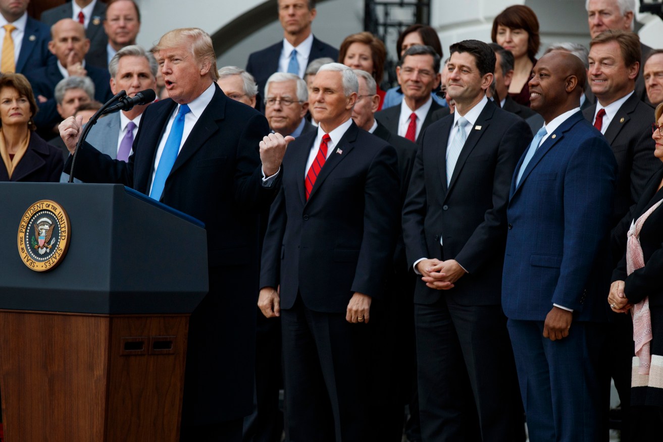 President Donald Trump celebrates the passage of the tax overhaul legislation at the White House. Photo: AP/Evan Vucci
