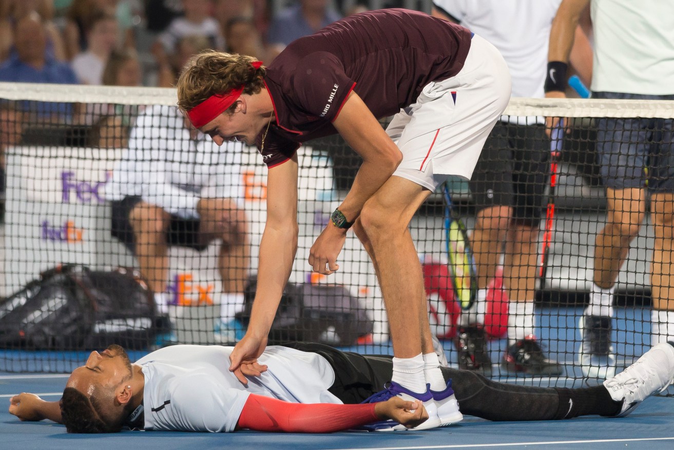 Alexander Zverev helps Nick Kyrgios up after hitting him with the ball during last night's Fast Fours doubles match. Photo: Craig Golding / AAP