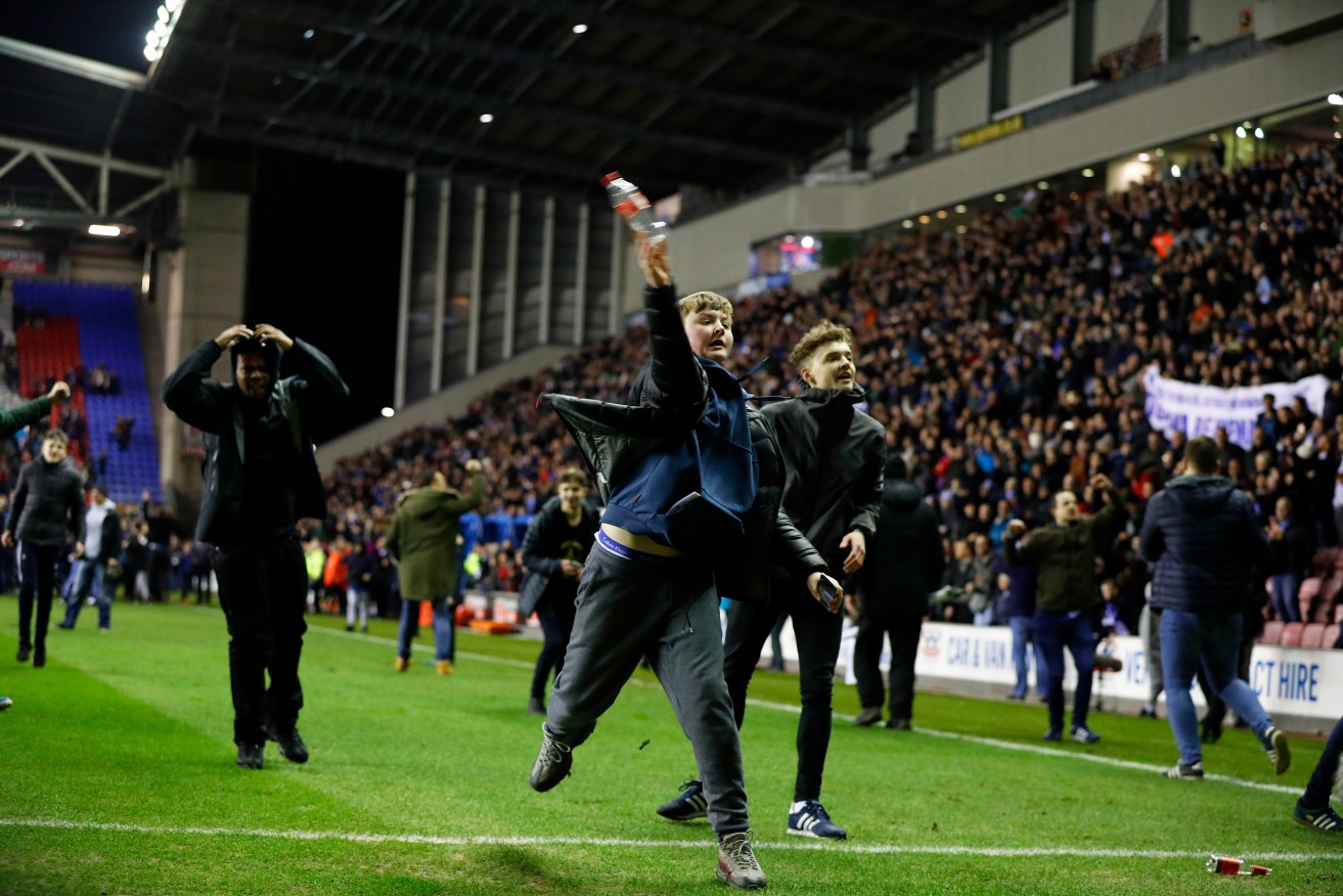 Fans invade the pitch after Wigan defeated Manchester city at the DW Stadium, Wigan. Photo: Lynne Cameron/Sportimage via PA Images.