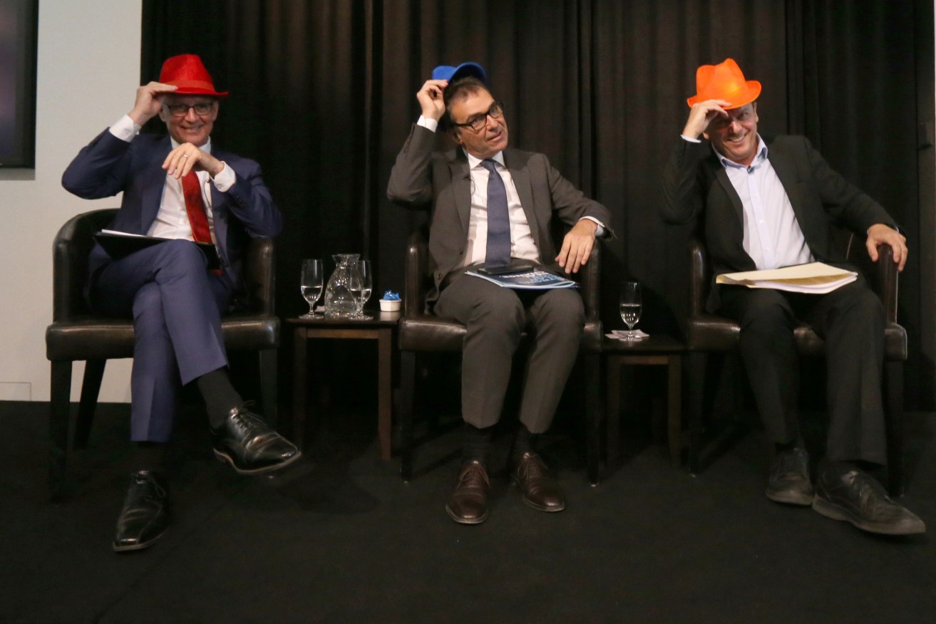 Premier Jay Weatherill, Liberal leader Steven Marshall and SA Best leader Nick Xenophon wear their parties' colours at a SACOSS leaders debate this week. Photo: AAP/Kelly Barnes