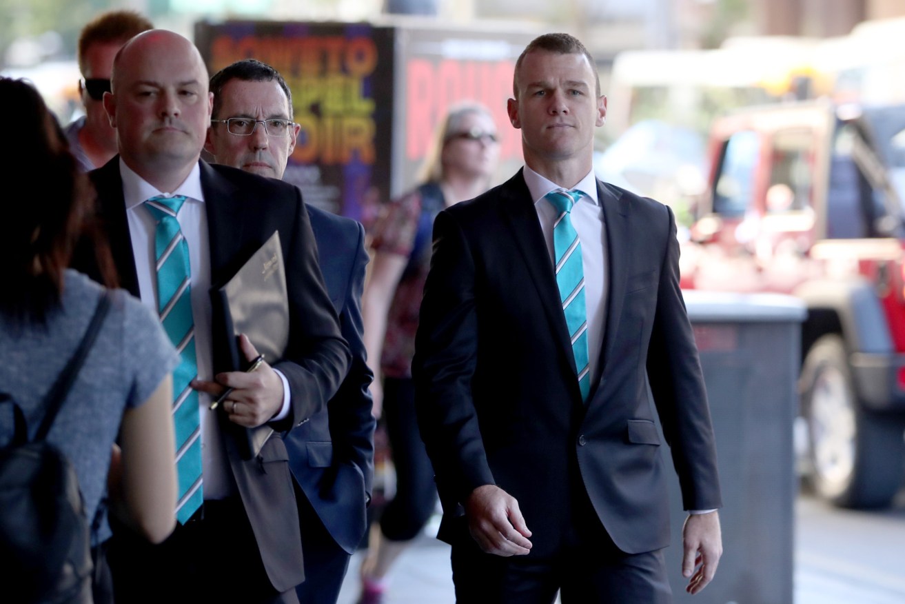Robbie Gray (right) arrives for his AFL Tribunal hearing in Adelaide yesterday. Photo: AAP/Kelly Barnes