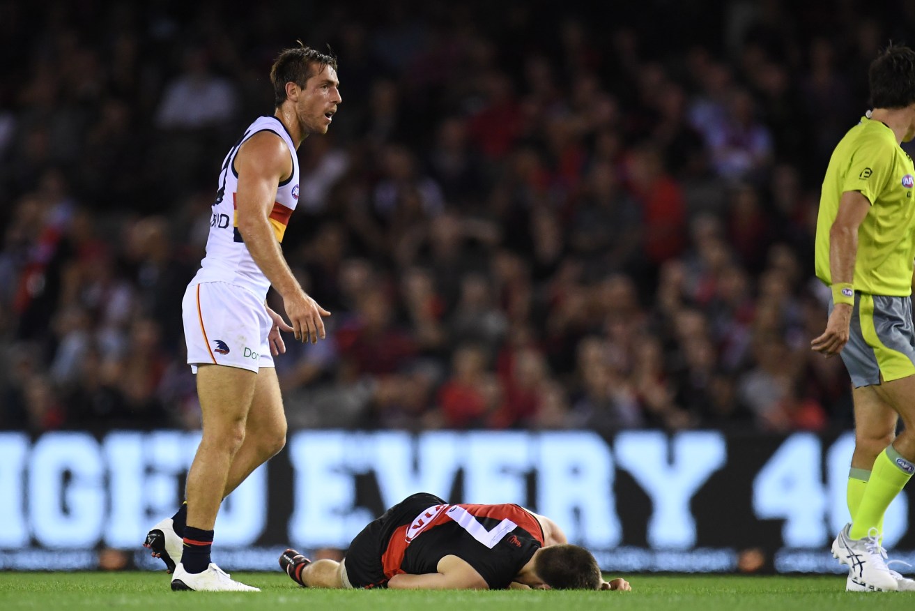 Richard Douglas stands over Zach Merrett after they clashed on Friday. Photo: AAP/Julian Smith