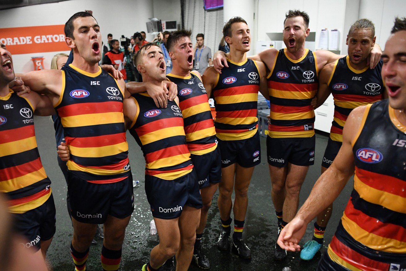 Four-goal skipper Tex Walker (second from left) leads his team in the club song after a memorable debut for Myles Poholke (right). Photo: David Moir / AAP