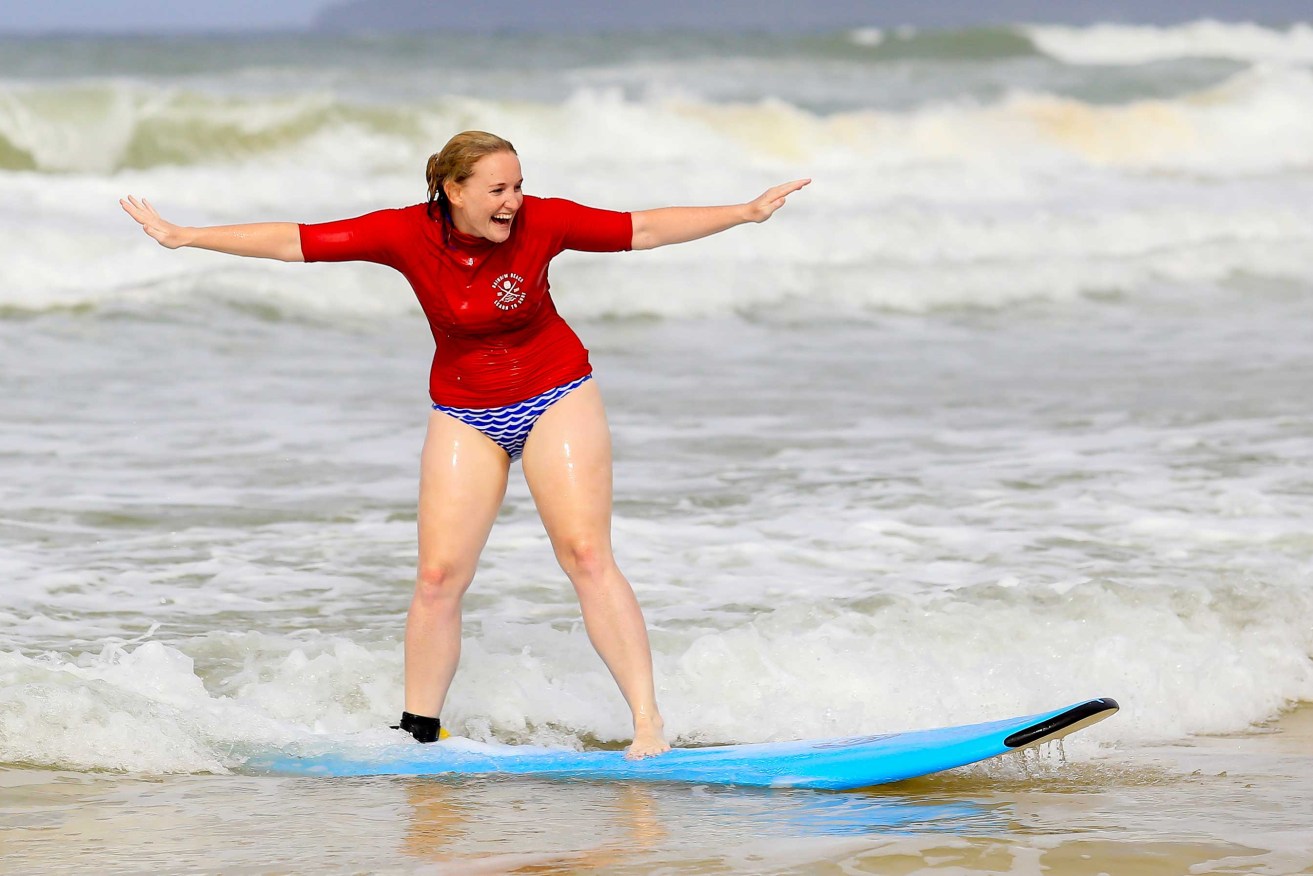 A woman learning to surf at Rainbow Beach near Noosa. Photo: Supplied