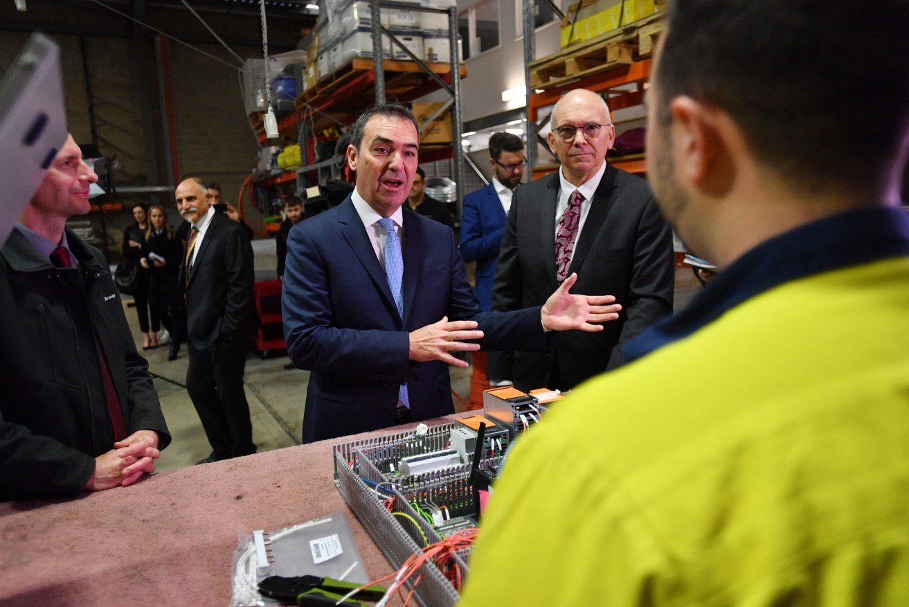 Premier Steven Marshall (centre) and SA Minister for Industry and Skills David Pisoni at Dematec Automation today. Photo: AAP/David Mariuz
