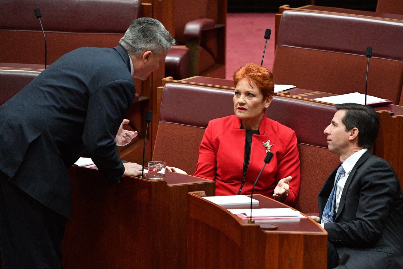 Finance Minister Mathias Cormann (left) with Pauline Hanson and  Education Minister Simon Birmingham before the tax vote today. Photo: AAP/Mick Tsikas