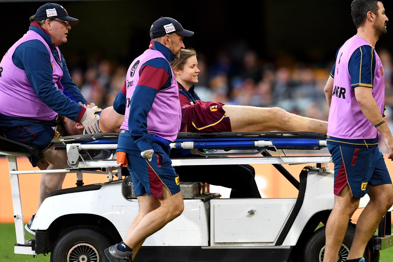 Harris Andrews is taken off the field after the collision with Cameron. Photo: AAP/Dan Peled