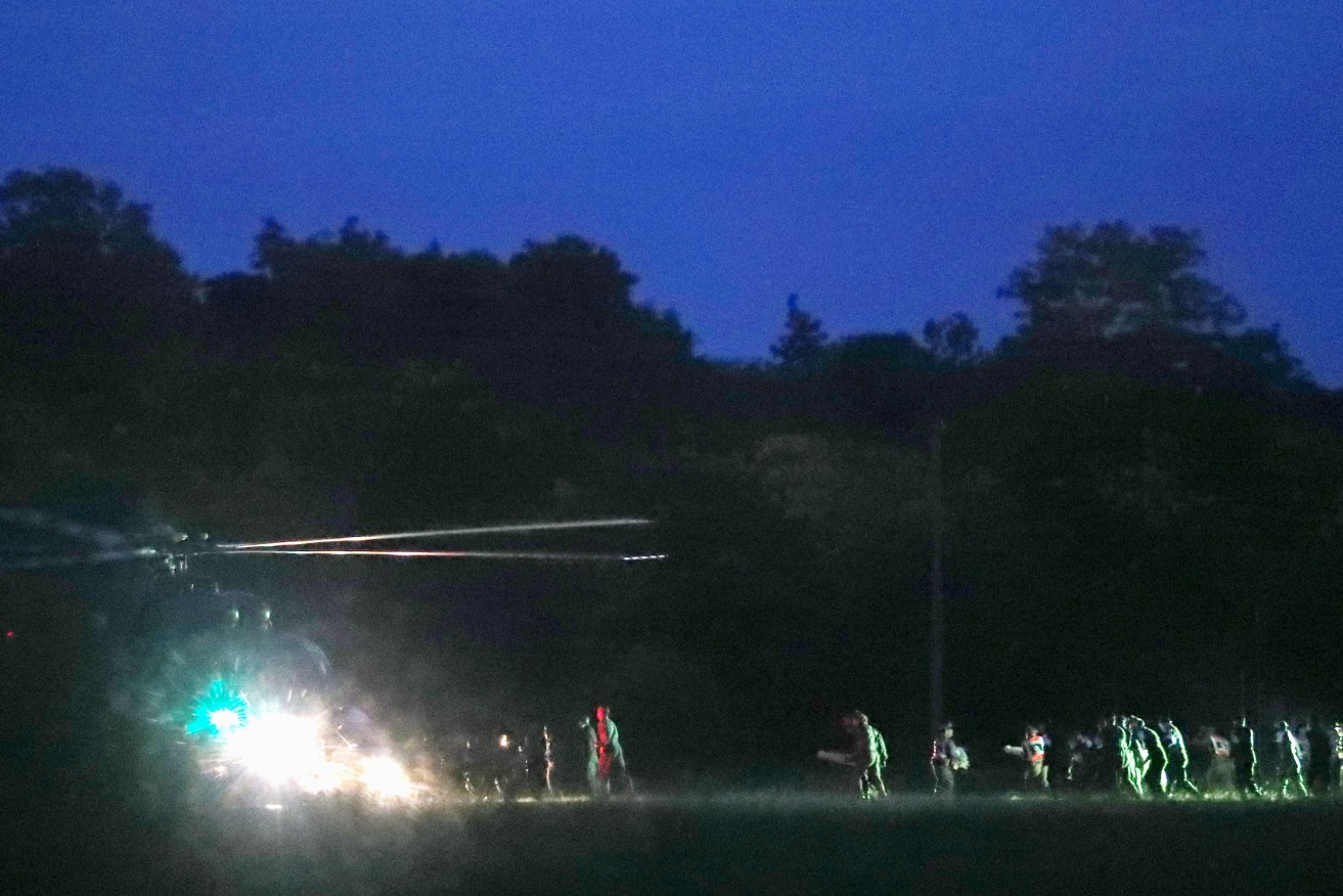 Thai medics and police officers evacuate the first two children with a helicopter. Photo: EPA/Rungroj Yongrit
