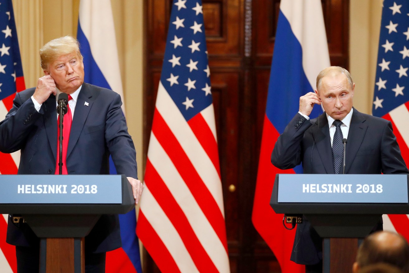 US President Donald J. Trump and his Russian counterpart Vladimir Putin adjust their earpieces during a joint press conference in  Helsinki. Photo: EPA/Anatoly Maltsev
