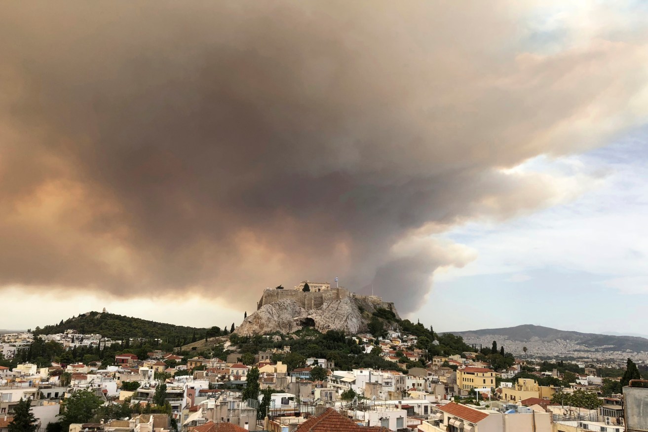 A pall of smoke turns large parts of the sky orange behind the ancient Acropolis. Photo: AP/Theodora Tongas