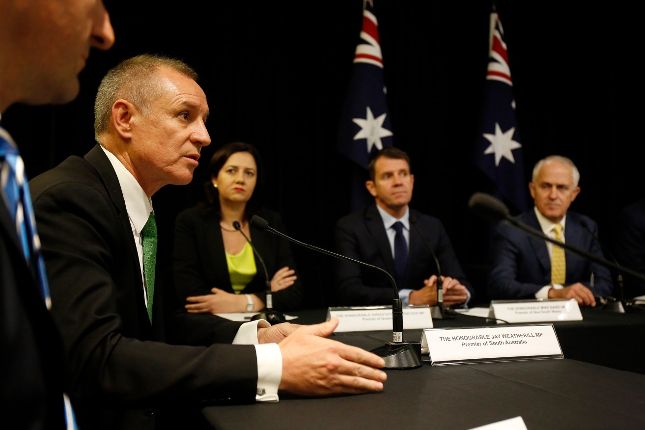 Malcolm Turnbull (right) watches on as then-premier Jay Weatherill addresses media after a COAG meeting. Photo: David Moir / AAP