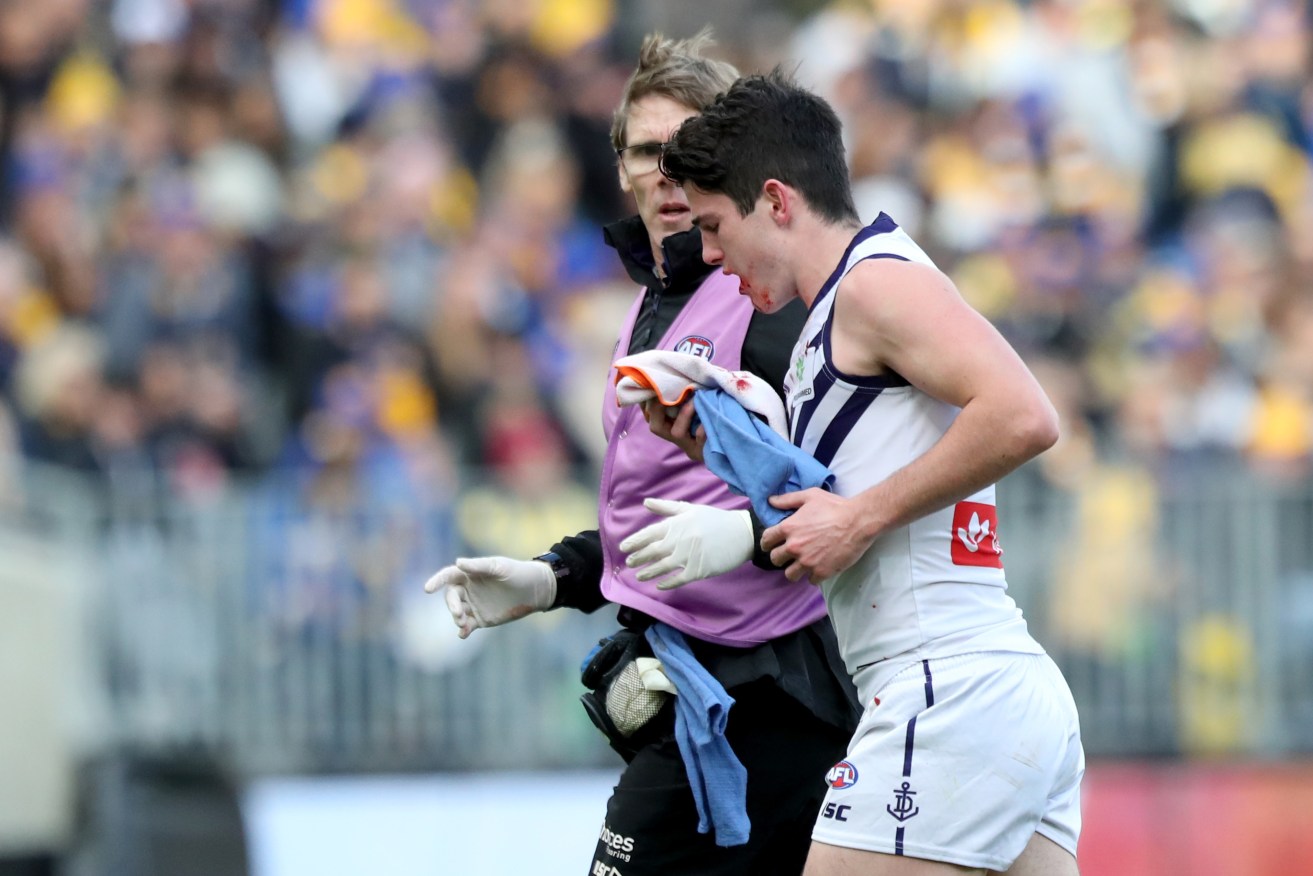 Andrew Brayshaw leaves the field yesterday after being punched by Eagle Andrew Gaff. Photo: AAP/Richard Wainwright