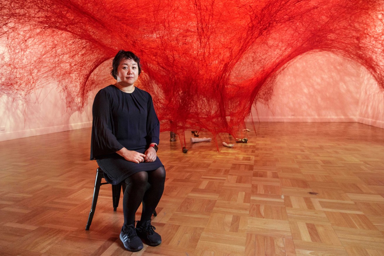 Chiharu Shiota in front of her work Absence Embodied, on display at the Art Gallery of SA. Photo: Saul Steed