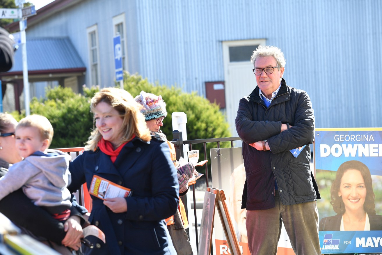 Alexander Downer keeps an eye on Rebekha Sharkie on the hustings as she speaks to voters - whom he broadly blames for the nation's decade of political instability. Photo: David Mariuz / AAP