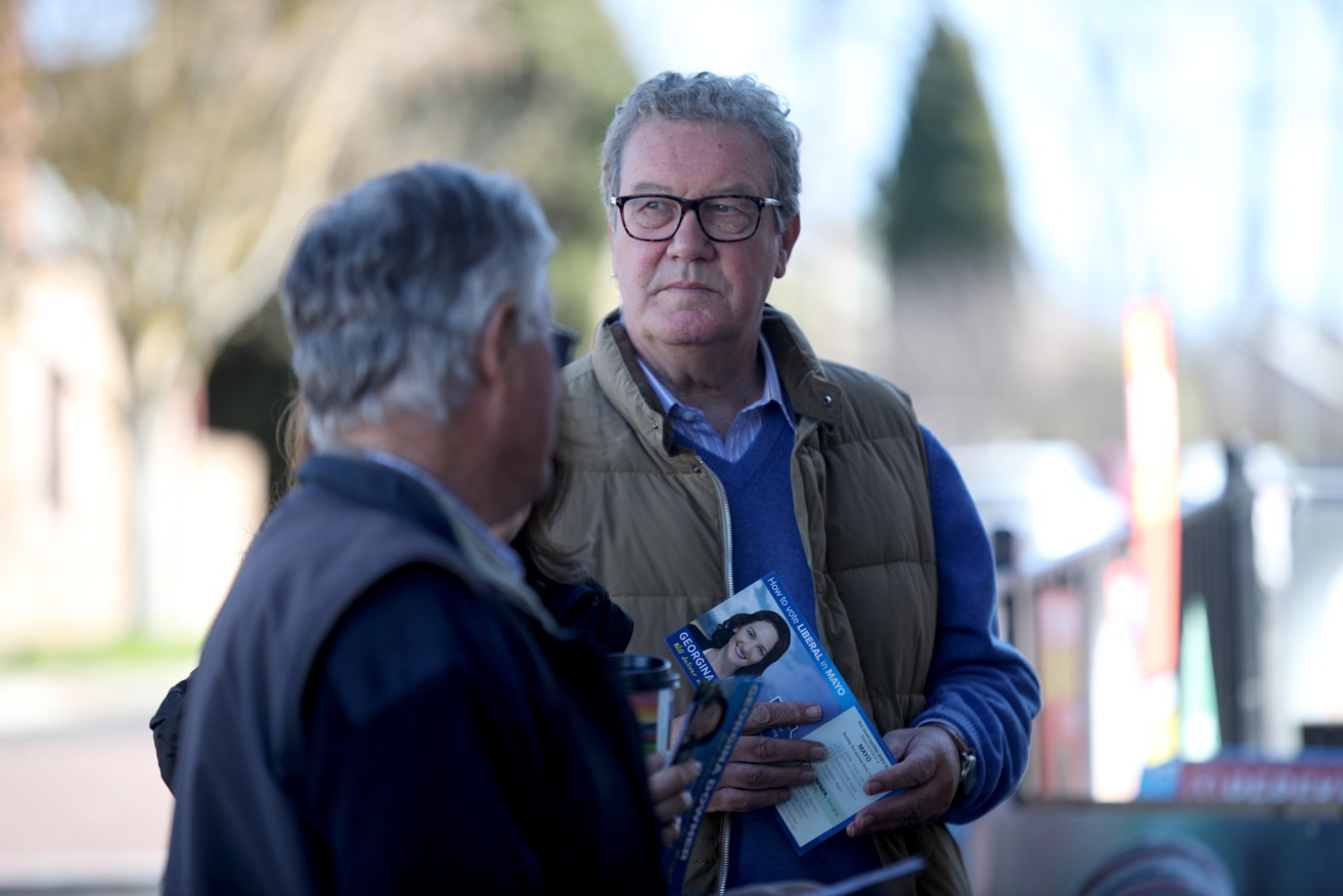 Alexander Downer handing out how-to-vote cards for his daughter Georgina. Photo: Kelly Barnes / AAP