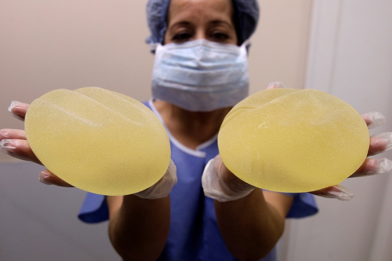 A nurse holds defective breast implants manufactured by French company Poly Implant Prothese (PIP). Photo: AP/Lionel Cironneau