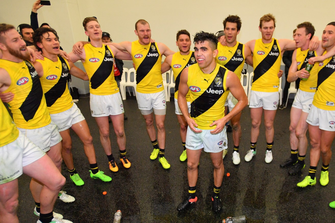Tyson Stengle celebrates his first AFL game with Tigers teammates - a win against Port Adelaide. Photo: David Mariuz / AAP