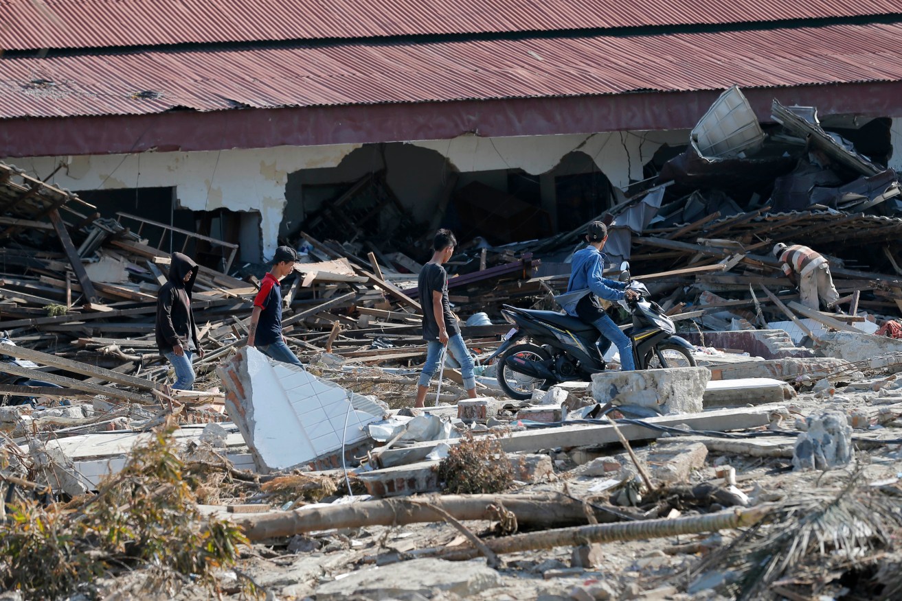 People survey the damage following a massive earthquake and tsunami at Talise beach in Palu. Photo: AP/Tatan Syuflana