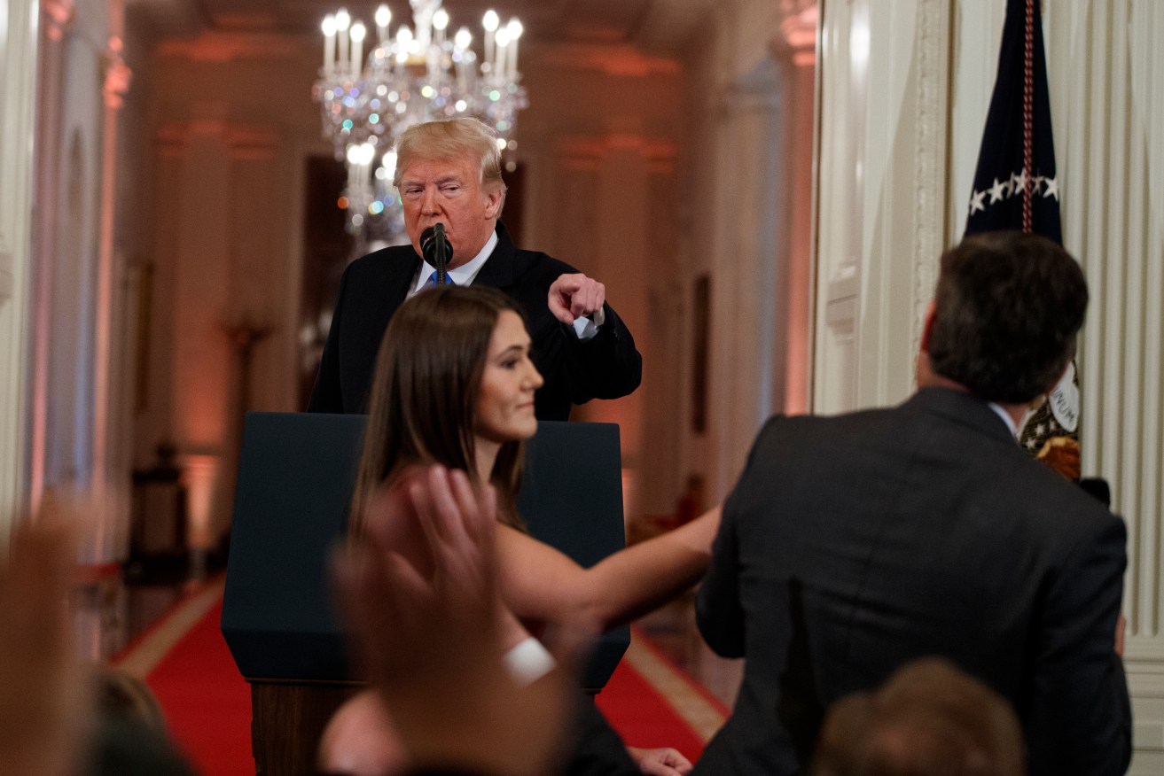 President Donald Trump looks on as a White House aide attempts to take away a microphone from CNN journalist Jim Acosta. Photo: AP/Evan Vucci