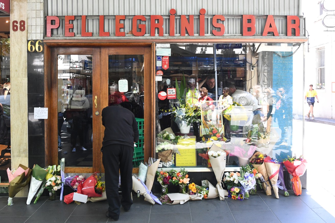 Mourners pay their respects outside of Pellegrini's Espresso Bar in Bourke Street. Co-owner Sisto Malaspina was killed in Friday's attack. Photo: AAP/James Ross