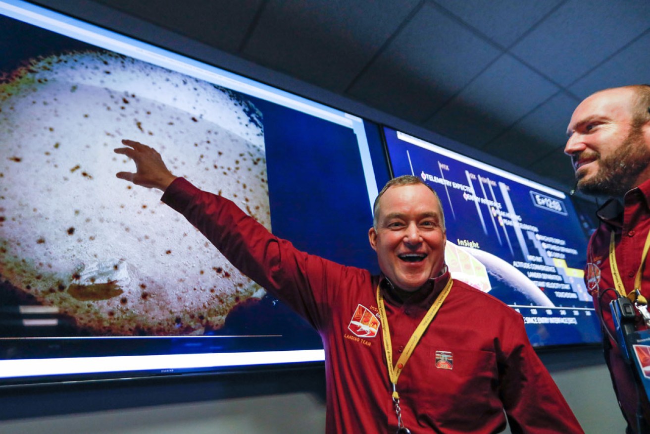 Touchdown: NASA's Tom Hoffman points to the first image seen from the Mars InSight lander. Photo: EPA