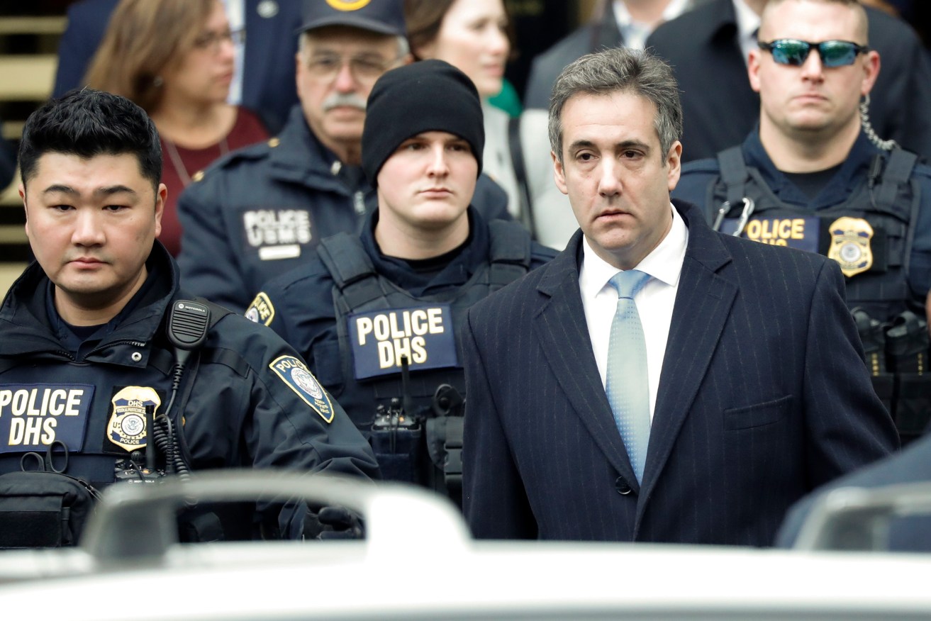 Michael Cohen (front right) leaves a New York court after being sentenced to three years in prison. Photo:   EPA/Jason Szenes
