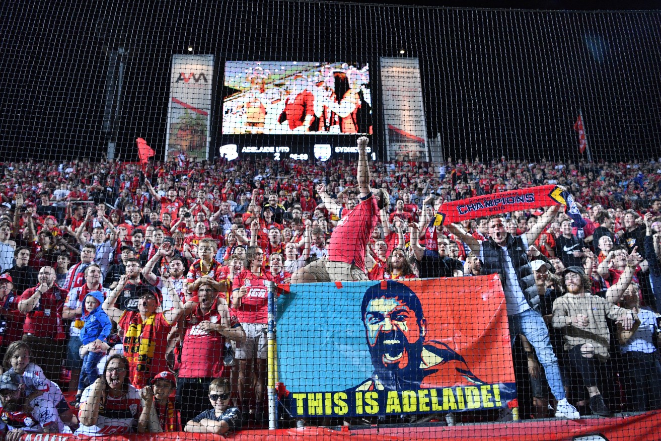 Ecstatic Adelaide United fans at the club's headequarters, on Manton Street, Hindmarsh. Photo: AAP/David Mariuz
