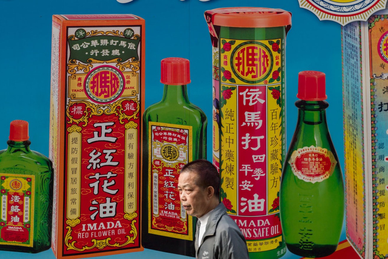 A man walks past a truck displaying an ad for medicinal oils in a Sham Shui Po market. Photo: EPA