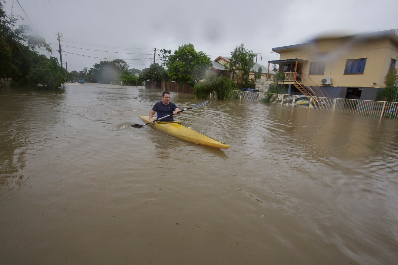 Graham Crighton kayaking in flood waters in Townsville. Photo: AAP/Andrew Rankin