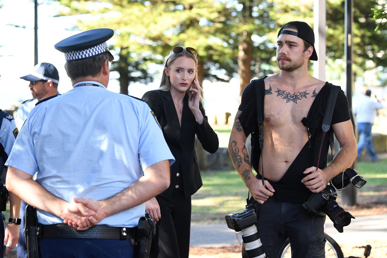 NewsCorp photographer Dylan Robinson (right) and reporter Eliza Barr (centre) are seen after a confrontation with a member of the public following a press conference with Senator Fraser Anning at Dunningham Park in Cronulla. Photo: Joel Carrett / AAP