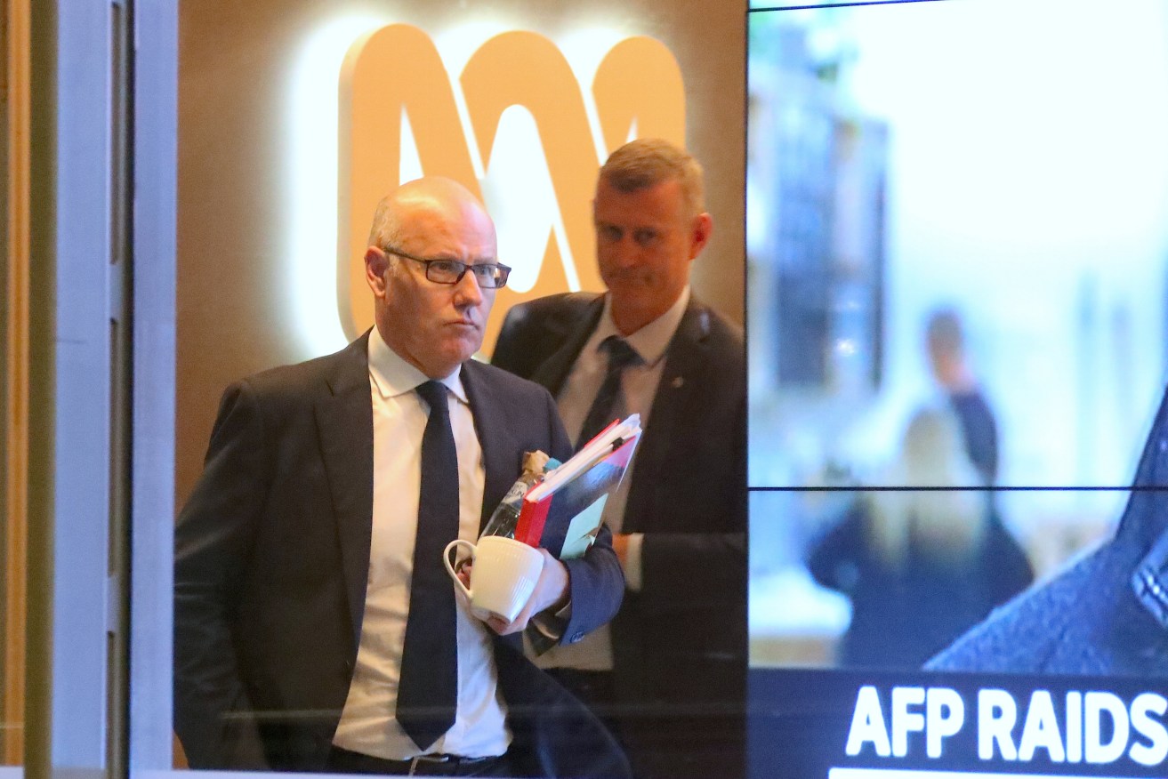 ABC executive editor John Lyons and an AFP officer at ABC's Sydney offices during the raid.  Photo: AAP/David Gray