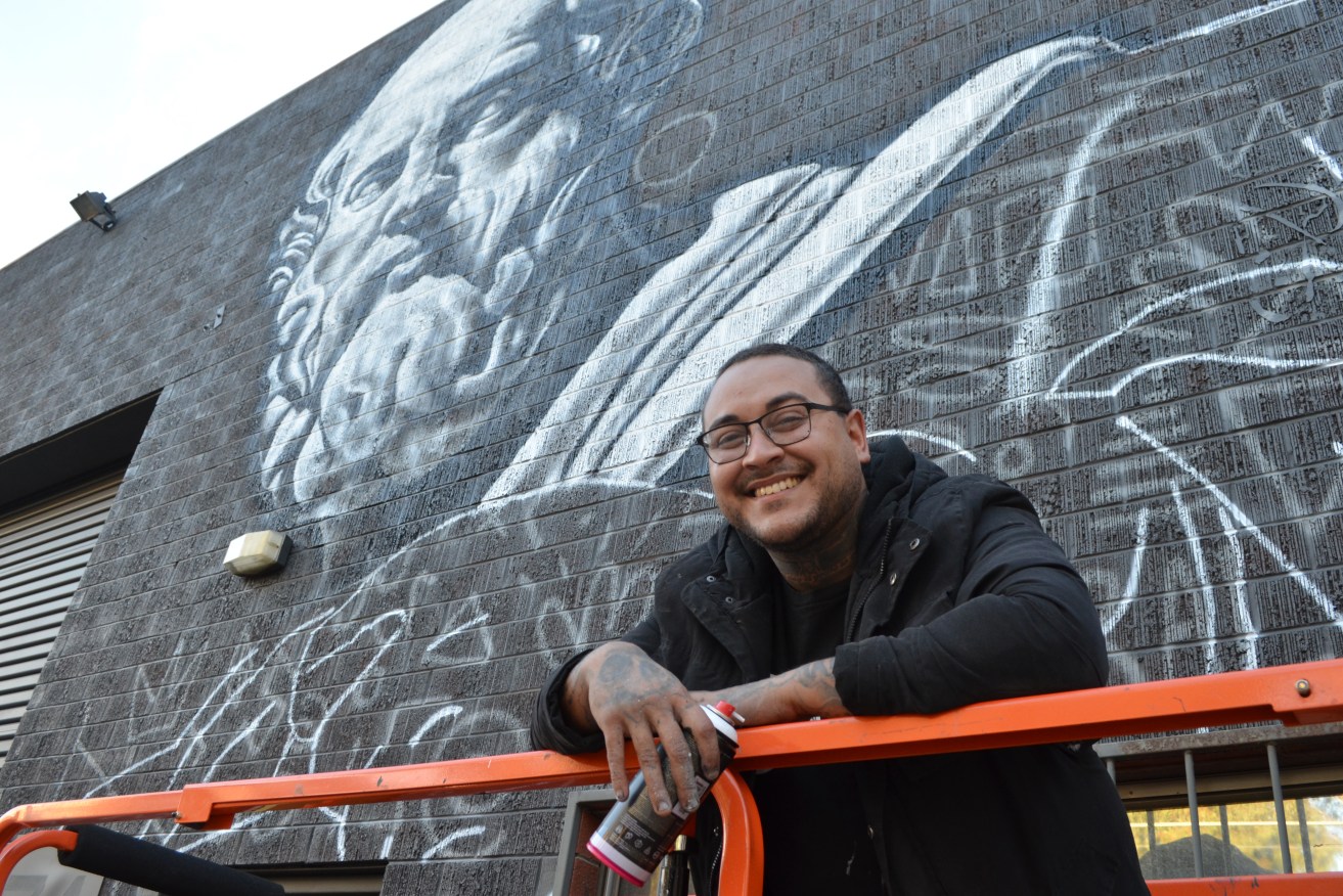Thomas Readett on the first day of his Praxis mural project. Photo: Angela Skujins