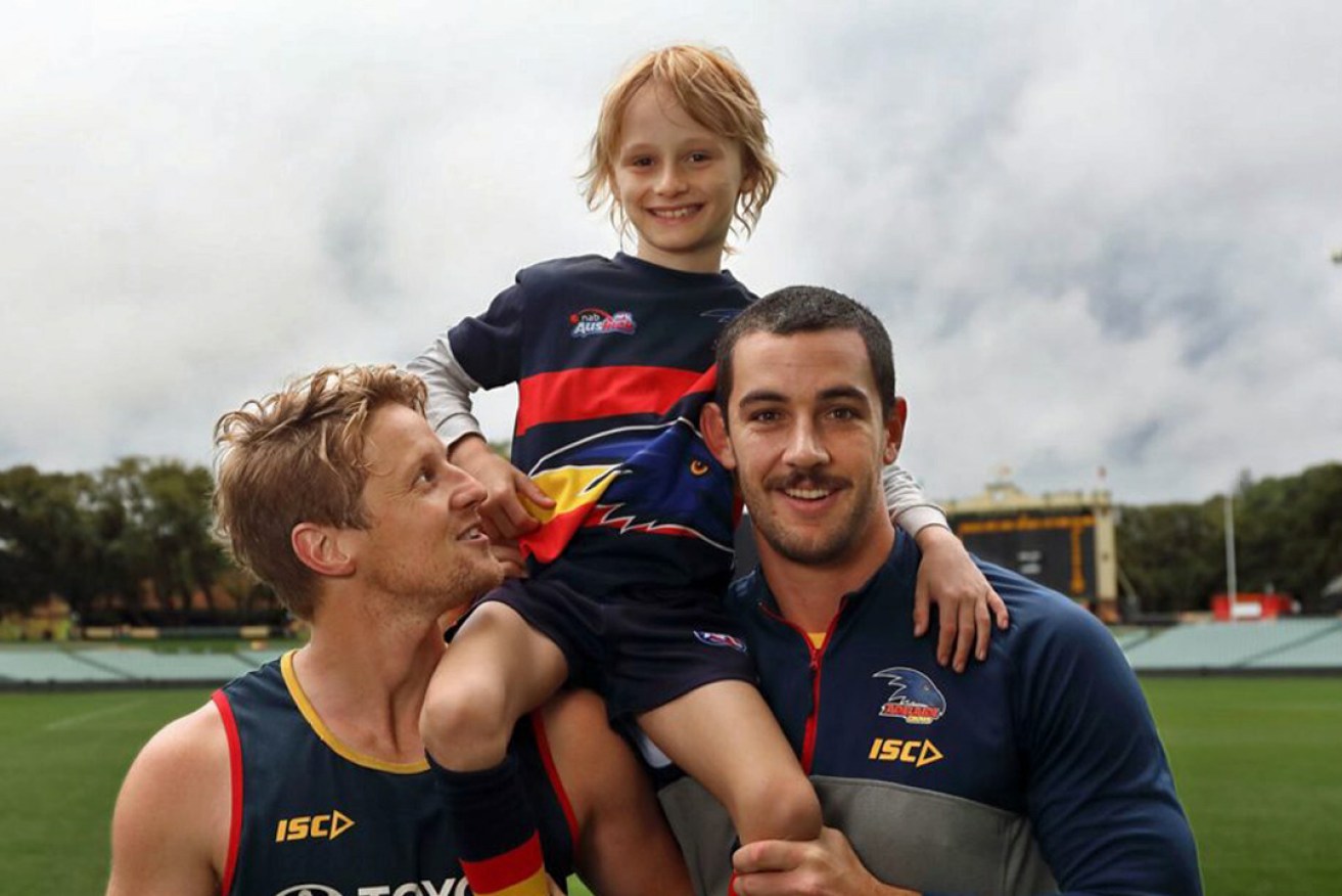 Sullivan Latch with his Crows heroes, Rory Sloane and Taylor Walker. Photo: Tony Lewis/InDaily