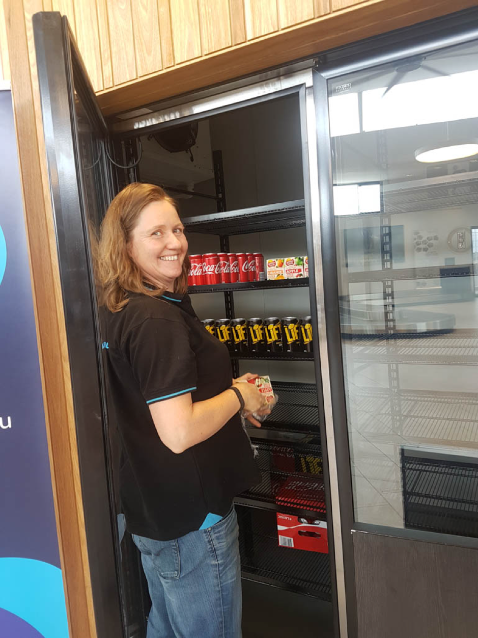 Mobo Group employee Bec Davis restocks the beverages. Bec, along with fellow employees Carmel and Julie, were instrumental in bringing the café to fruition.