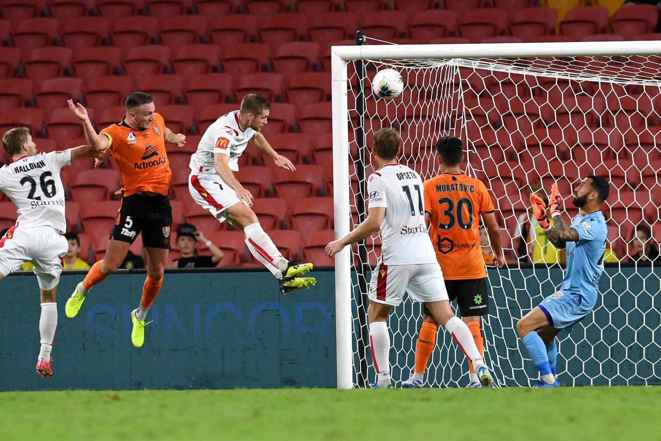 Brisbane's Tom Aldred  scores one of the Roar's two goals  in seven minutes to sink the Reds. Photo: AAP/Dan Peled