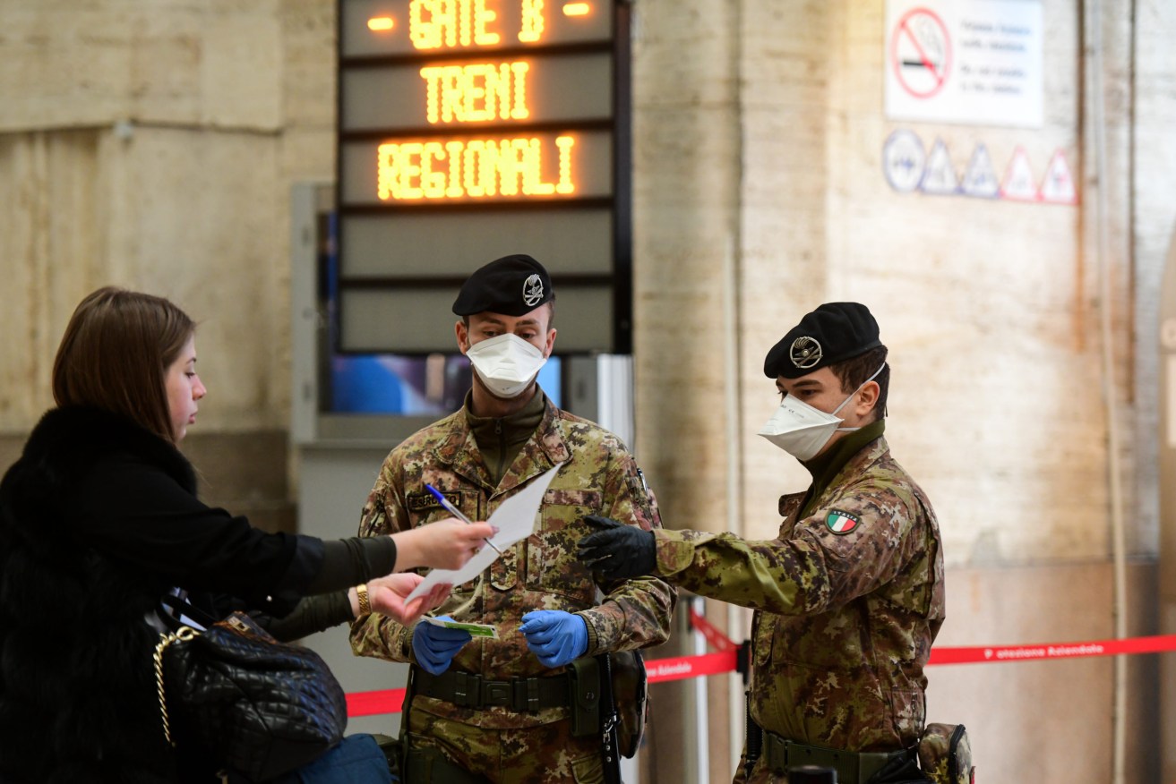 Italian soldiers check passengers at a train station as travel restrictions are enforced. Photo: Piero Cruciatti/Sipa USA)