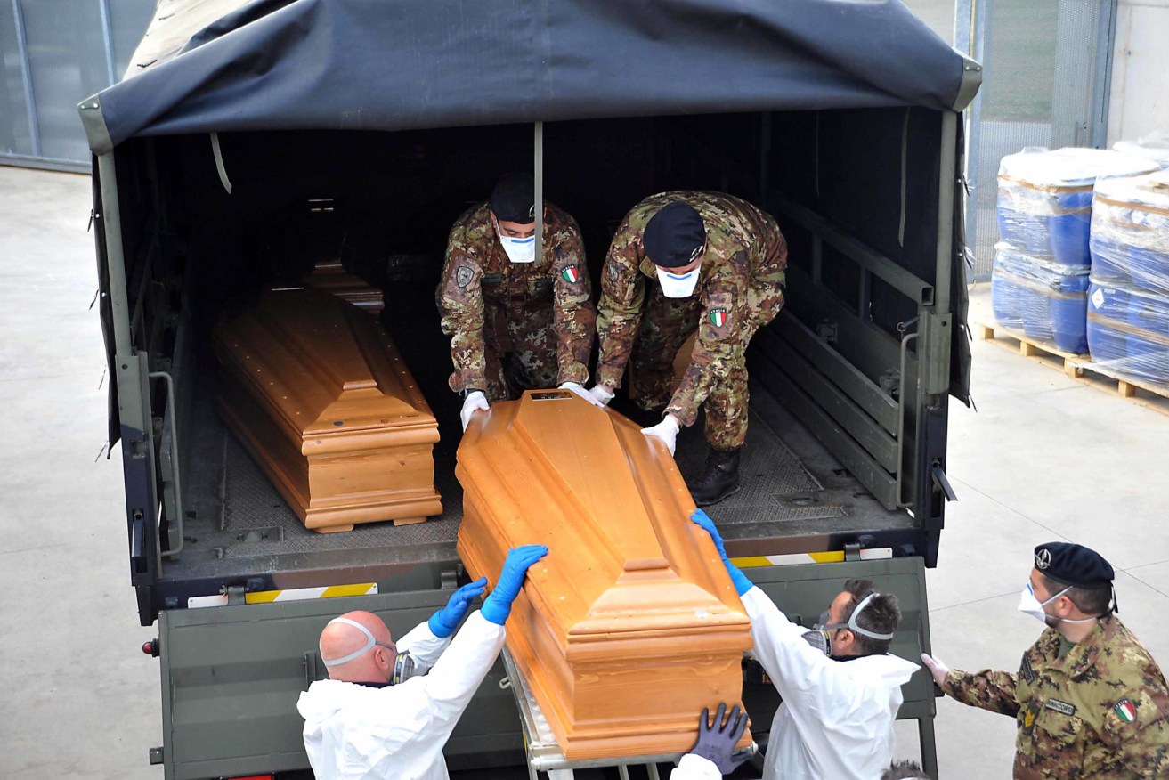Italian army trucks are loaded with coffins. Photo: EPA/Sergio Pesci