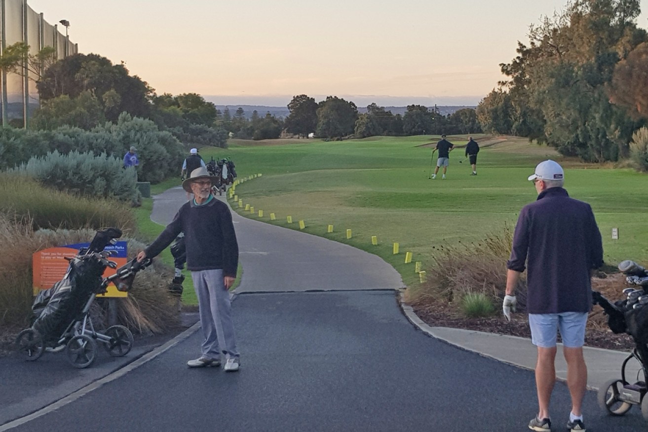 Players prepare to tee off at West Beach Parks' south course at 7.30am this morning.