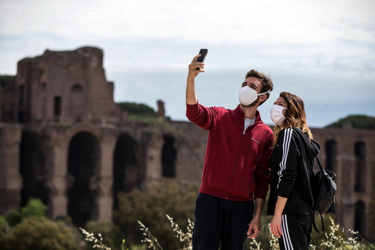 A masked couple take a selfie in Rome on the weekend. Photo: EPA/Angelo Carconi