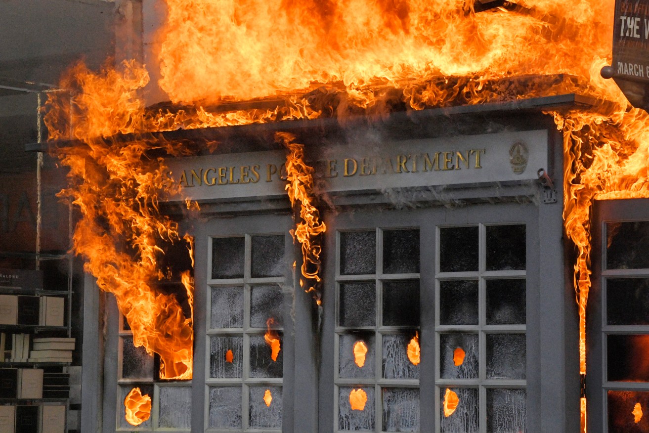 A Police Department kiosk ablaze in Los Angeles. Photo: AP/Mark J. Terrill