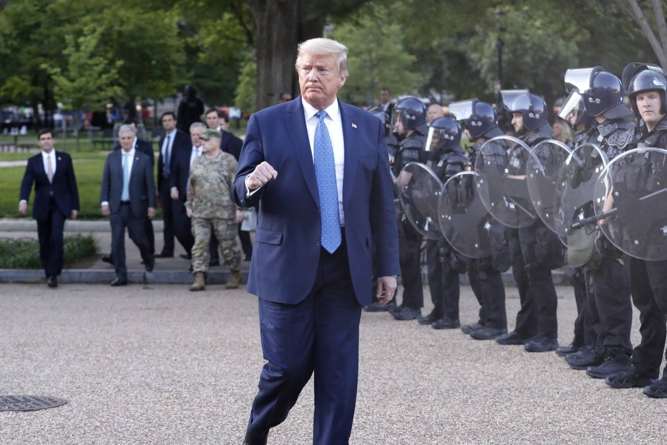 Donald Trump is guarded by riot police after visiting a church near the White House. Photo: supplied